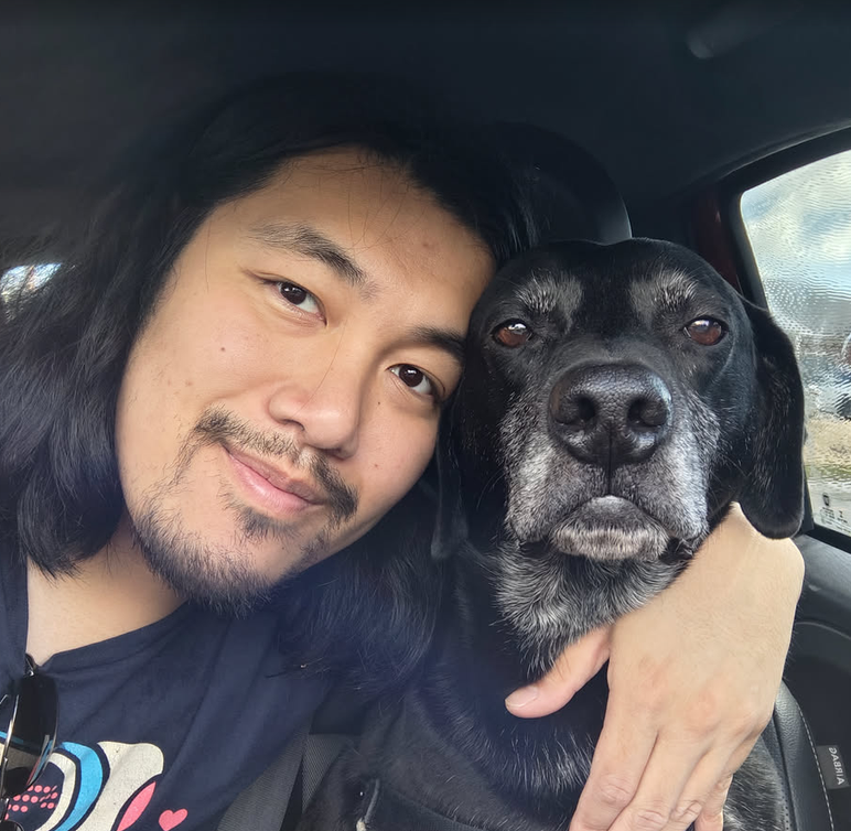 Pongo and Dr. Wang together in the car, looking at the camera